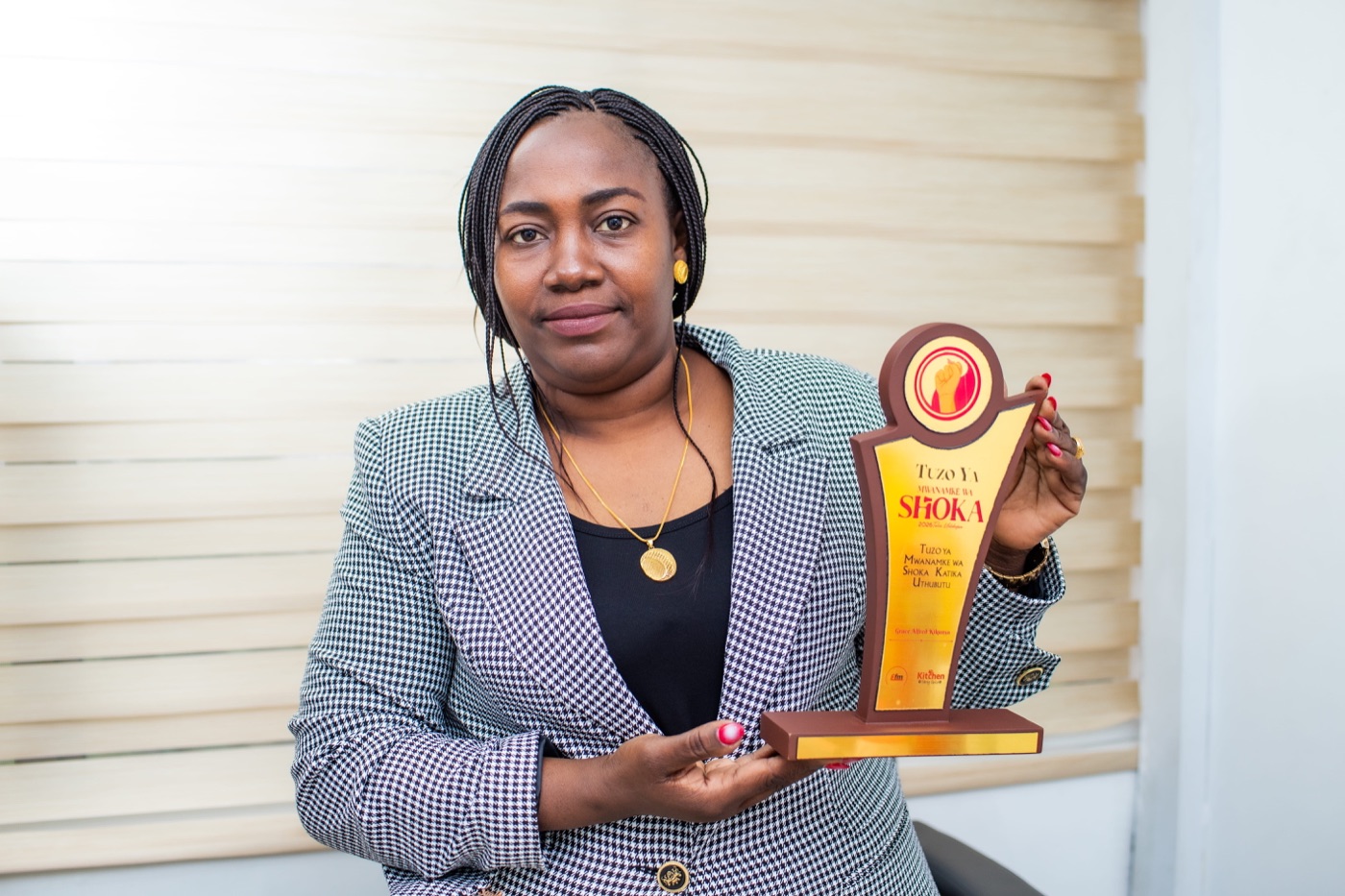 Grace Alfred Kikunya holding the Mwanamke wa Shoka award
